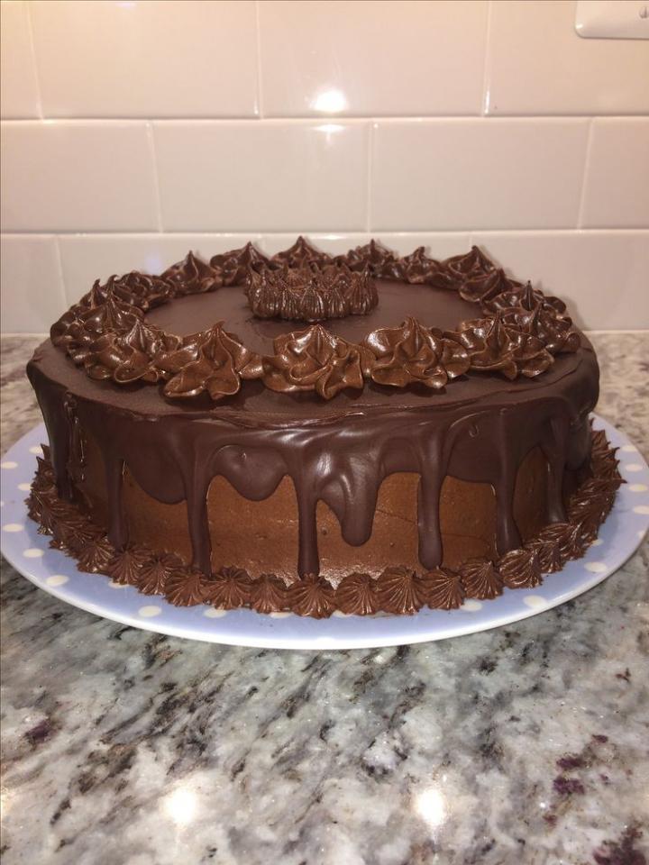 Chocolate cake with piped frosting and a glossy chocolate drip