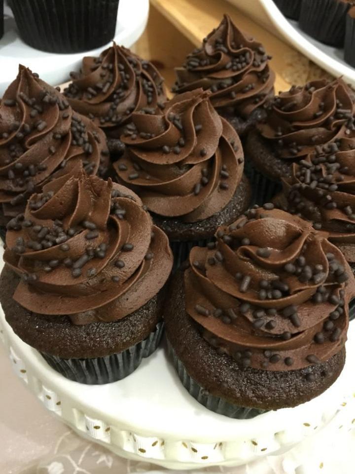 Chocolate cupcakes topped with swirled frosting and sprinkles